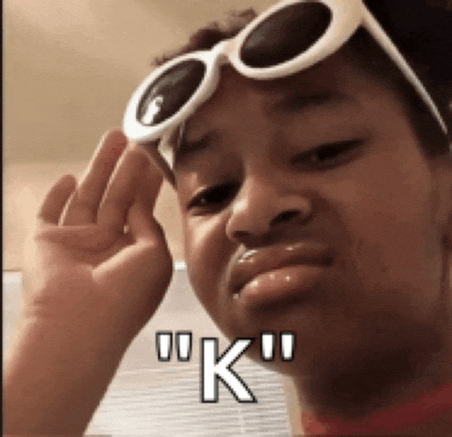 a girl wearing sunglasses is making a funny face and says " k "