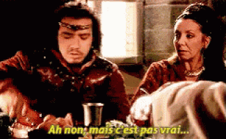 a man and a woman are sitting at a table and the man says " ah non mais c est pas vrai "