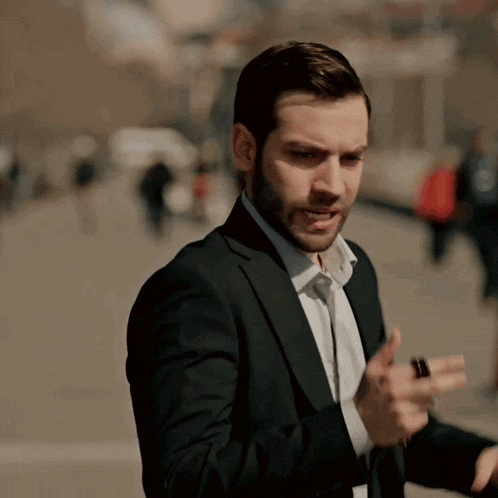a man in a suit and white shirt is talking on his phone