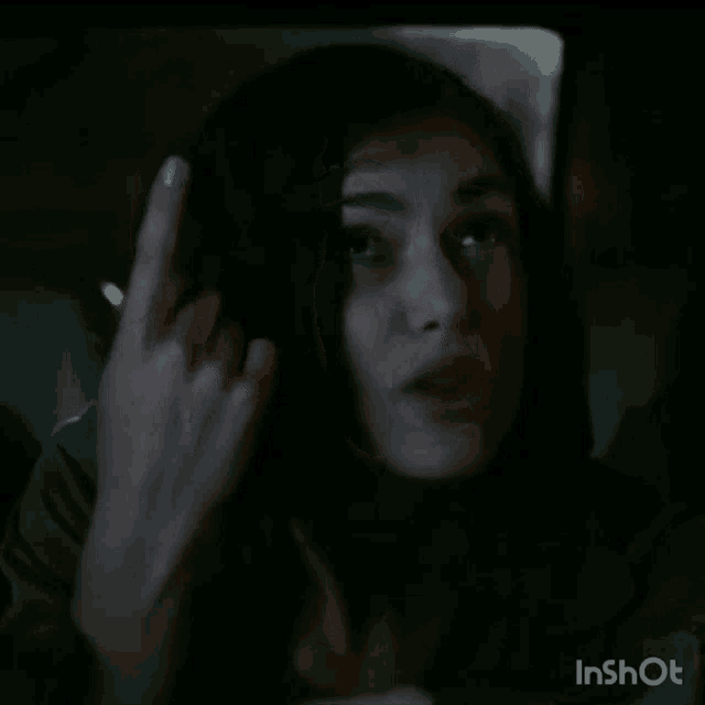 a woman is giving the middle finger while sitting in a car