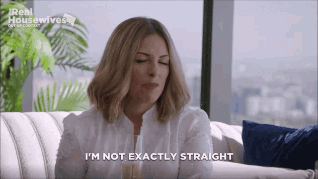 a woman says i 'm not exactly straight while sitting on a white couch