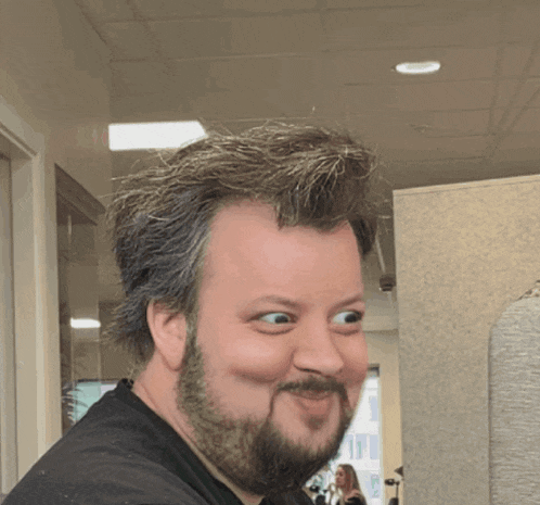 a man with a beard is making a funny face with his eyes closed