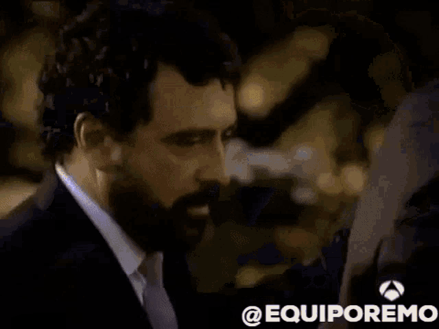 a blurry picture of a man with his hands on his head and the words equiporemo on the bottom .