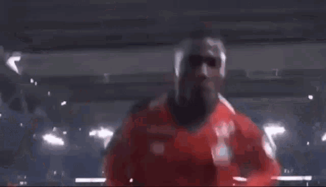two soccer players in red jerseys are giving each other a peace sign .