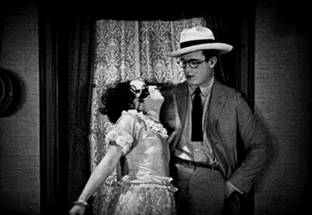 a man and a woman are standing next to each other in a room .