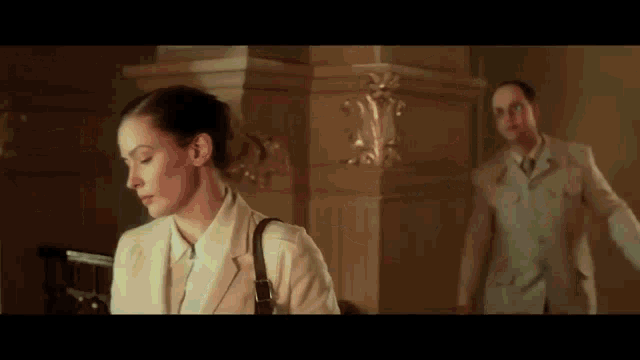 a man and a woman are standing next to each other in a hallway