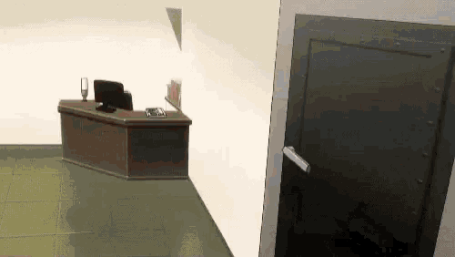 a computer is sitting on a desk in a room with a door .
