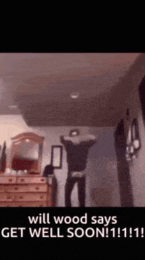 a man is standing in a room with his arms in the air .
