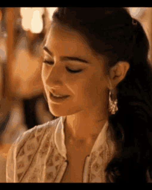 a close up of a woman 's face with her eyes closed and a smile on her face .