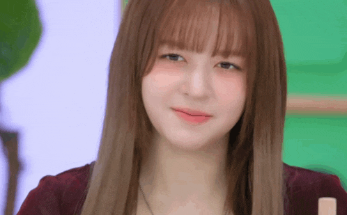 a close up of a young woman with long hair and bangs looking at the camera .