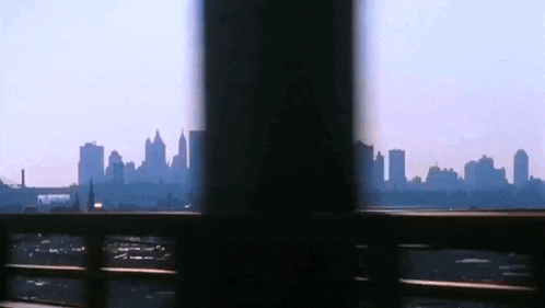 a view of a city skyline through a fence