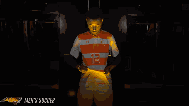 a man in a soccer uniform with the number 13 on it