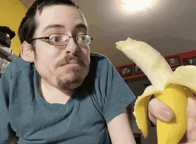 a man wearing glasses is holding a banana