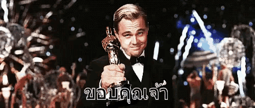 a man in a tuxedo holds an oscar trophy in front of a sign that says ' leonardo dicaprio '