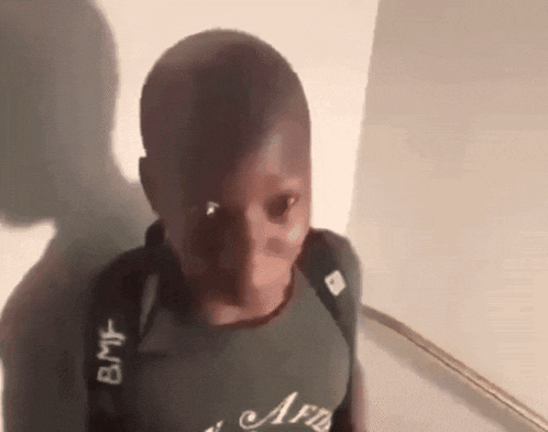 a young boy wearing a backpack and a t-shirt with the word afb on it .