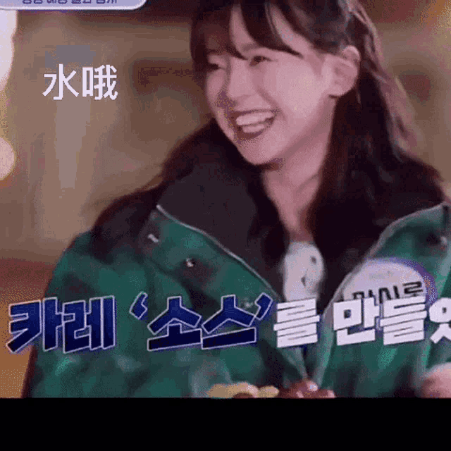 a woman in a green jacket is smiling in a foreign language
