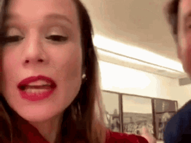 a close up of a woman 's face with red lipstick .
