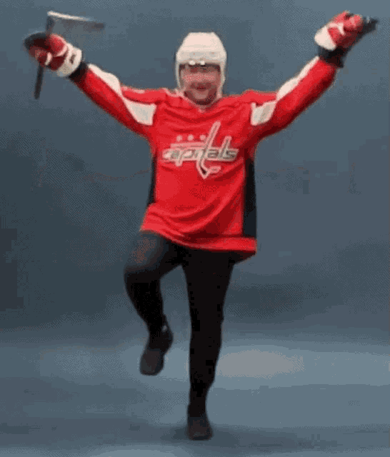 a man in a washington capitals jersey is dancing