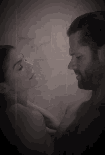 a man and a woman are looking at each other in a black and white photo