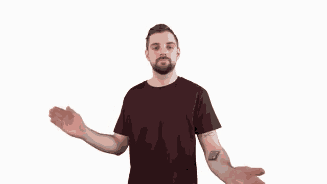 a man in a maroon shirt is making a stop sign with his hands