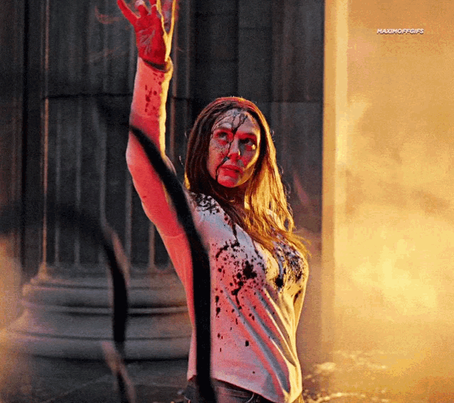 a woman with blood on her face is standing in front of a building with a caption that starts with the letters m and o