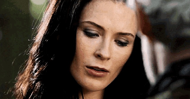 a close up of a woman 's face with dark hair