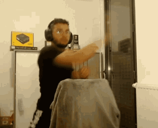a man wearing headphones and glasses is dancing in front of a yellow box that says hdmi