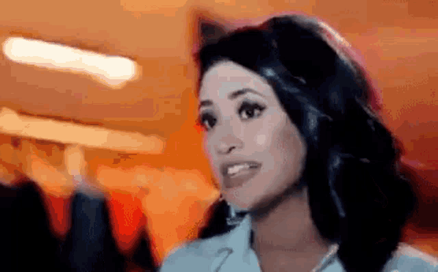 a close up of a woman 's face with a blurred background and a smile on her face .