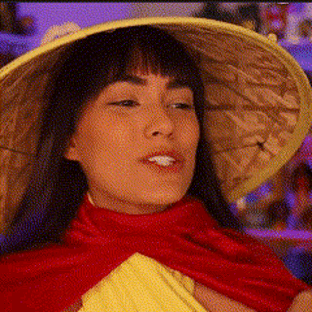 a woman wearing a yellow hat and a red scarf