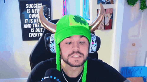 a man wearing a green hat with horns and a sign that says success is new
