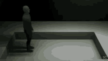 a silhouette of a person standing in a dark room with the letters sc on the floor