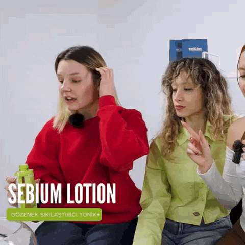 three women are sitting in front of a sign that says ' sebium lotion '