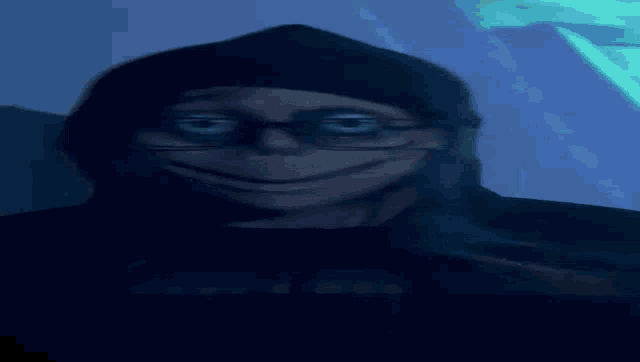 a close up of a person 's face with glasses and a hood .