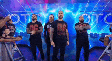 a group of men are standing next to each other on a stage in front of a blue background .