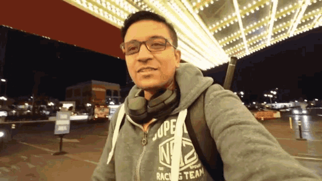 a man wearing a hoodie that says the racing team on it