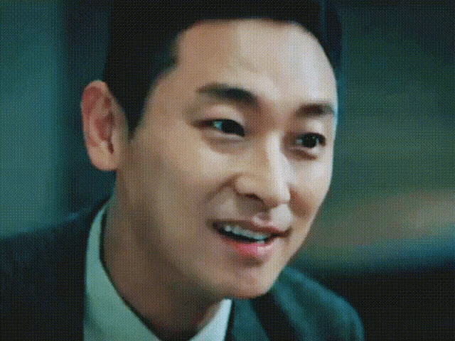 a man in a suit and tie is smiling and looking at the camera .
