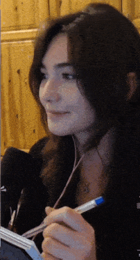 a woman is holding a pen in her left hand