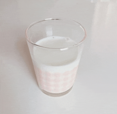 a glass of milk with a pink checkered pattern on the side