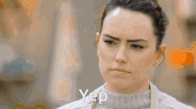 a woman wearing a grey sweater says yep