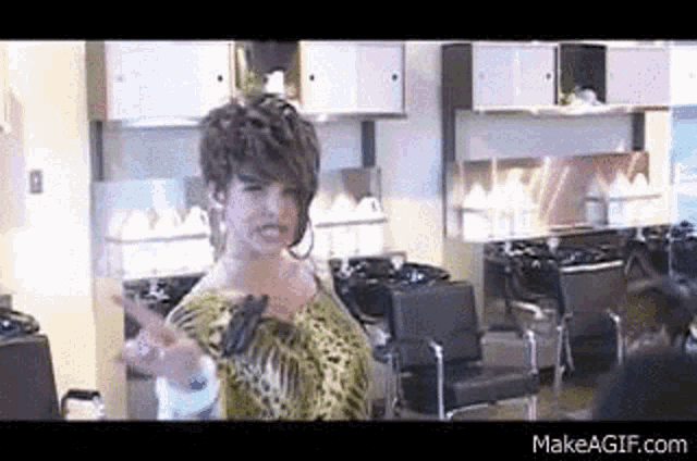 a woman is standing in a salon with a peace sign .