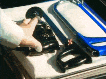 a person is holding a pair of shoes next to a saw