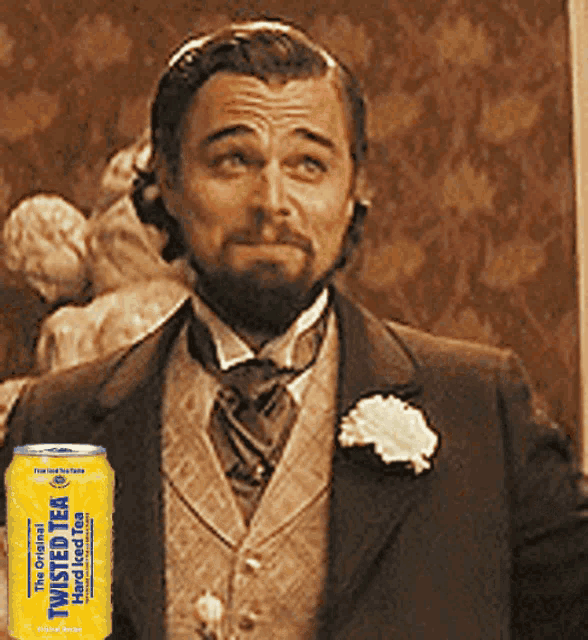 a man in a suit stands next to a can of twisted tea hard iced tea