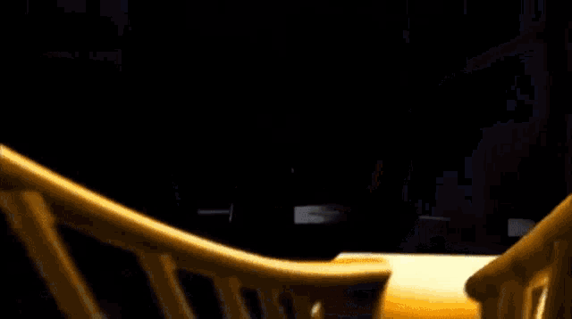 a blurred image of a staircase with a yellow railing and a black background