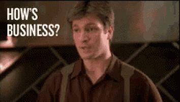 a man is standing in front of a wall and asking how 's business ?