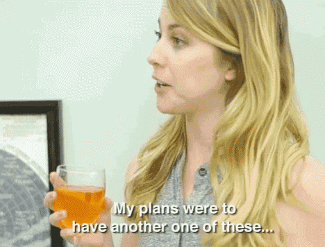 a woman is holding a glass of orange juice and says " my plans were to have another one of these "