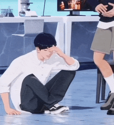 a man in a white shirt sits on the floor with his hand on his face