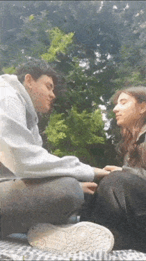a man and a woman are sitting next to each other and holding hands