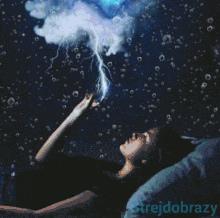 a woman is laying on a bed looking up at the sky with the words strejdobrozy written on the bottom