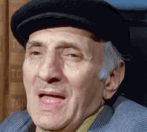 an elderly man wearing a black hat and a blue jacket