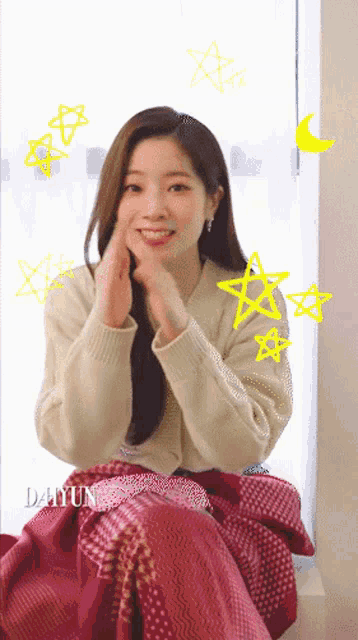 a woman is sitting on a window sill with a blanket around her and the word dahyun written on the bottom